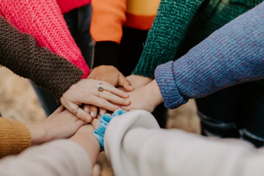 Diverse people joining hands to represent inclusion, equality and community